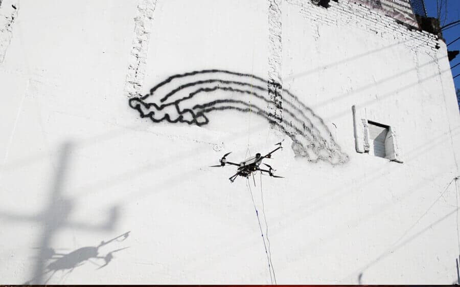 A Drone Spray Painting Edwards Design on the Wall in Mexico City