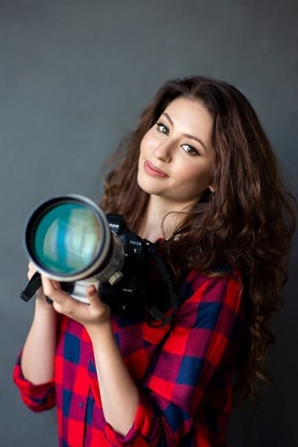 Ann Young Holding a Canon EOS 1 Camera in Grey Background