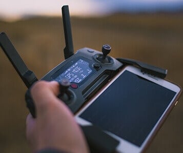 A powered on Mavic pro controller with two antennas and a Samsung mobile phone attached to it